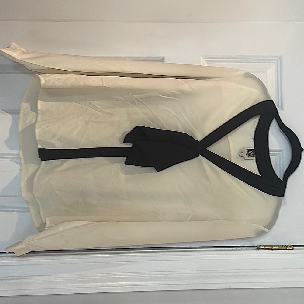 Cream colored blouse with black bow at neckline
